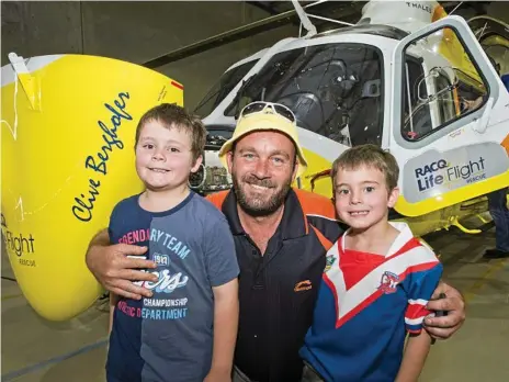  ?? Photos: Nev Madsen ?? ALL SMILES: Getting to see a chopper up close for the first time are (from left) Ethan, Steve and Alex Merrell at the RACQ LifeFlight Rescue Community Open Day in Toowoomba.