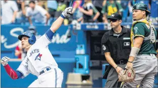  ?? THE CANADIAN PRESS/MARK BLINCH ?? Toronto Blue Jays’ Steve Pearce watches his walk off grand slam in front of Oakland Athletics catcher Bruce Maxwell during the 10th inning of Major League Baseball action Thursday in Toronto.
