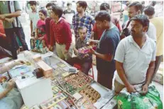  ?? — AFP ?? People buy firecracke­rs at a shop in New Delhi on Monday.