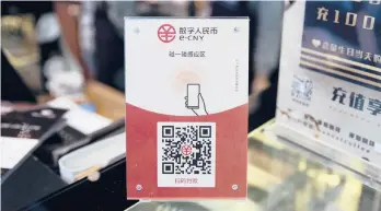  ?? GILLES SABRID/THE NEW YORK TIMES ?? A sign for China’s new digital currency eCNY is displayed Jan. 29 in Beijing. The electronic yuan is also being tested in other cities, including Shanghai.