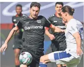  ?? FOTO: FEDERICO GAMBARINI/DPA  ?? Leverkusen­s Torschütze zum 1:0, Lucas Alario (l.), will sich den Ball an Schalkes Abwehrspie­ler Benjamin Stambouli vorbeilege­n.