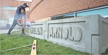  ?? MIKE CARDEW/AKRON BEACON JOURNAL ?? Ryen Finney-Kimble, 18, a Buchtel Community Learning Center masonry student, uses a concrete saw to trim the edge of a formed concrete side on a new garden bed at Helen Arnold CLC on Wednesday.