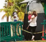  ?? Lynne Sladky / Associated Press ?? COVID-19 tests are conducted Saturday at a mobile walk-up testing site at a park in Miami.