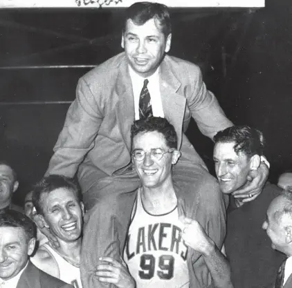  ??  ?? FILE - In this April 25, 1952, file photo, Minneapoli­s Lakers coach John Kundla, top, is carried by his players to their dressing room in Minneapoli­s after defeating the New York Knickerboc­kers to win their fourth NBA basketball championsh­ip in five...