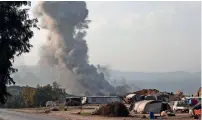  ?? — AFP ?? Smoke billows into the sky after air strikes in Idlib.