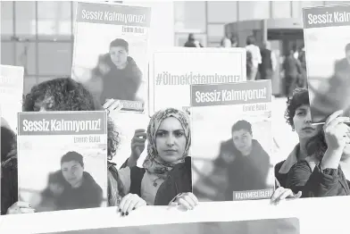  ?? — Gambar AFP ?? TUNTUT KEADILAN: Sekumpulan wanita memegang plakad dengan gambar Bulut ketika mereka berhimpun di luar mahkamah di bandar Kirikkale di tengah Anatolia, Turki semalam.