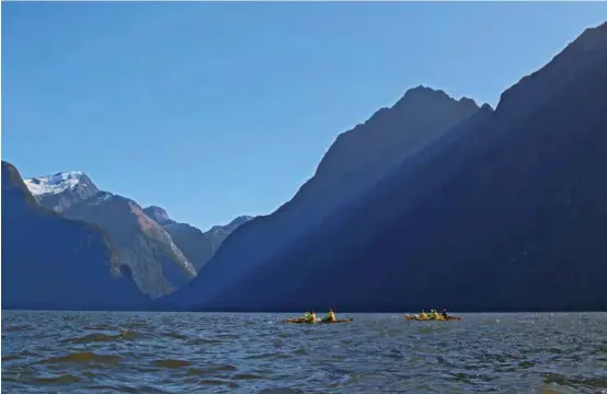  ??  ?? Dwarfed by the size of the mountain in Milford Sound