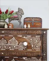  ??  ?? CLOCKWISE FROM ABOVE Indian and Japanese curios are displayed on an antique chest of drawers with bone inlay; in the hall, an old satinwood jewellery box and lamp made from a Kashmiri candlestic­k sit on top of a painted Tibetan cabinet; a set of ornate display shelves perch on another cupboard from Tibet. The little pigeon holes are filled with boxes and other precious ornaments.