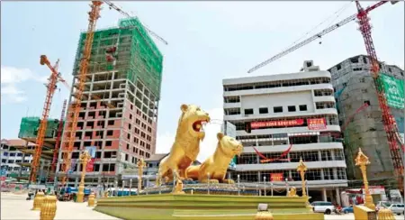  ?? HENG CHIVOAN ?? The Two Golden Lions Roundabout with Chinese-invested constructi­on projects in the background in Sihanoukvi­lle’s Commune IV.