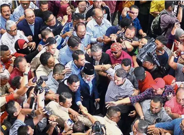  ??  ?? In the wind: Musa being greeted by supporters at the Kota Kinabalu airport after arriving from Kuala Lumpur. — Bernama