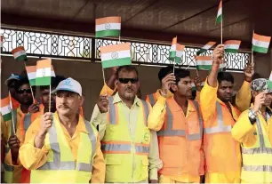  ??  ?? STURDY BACKBONE: Indian workers share patriotic moments with flags as part of the celebratio­ns.