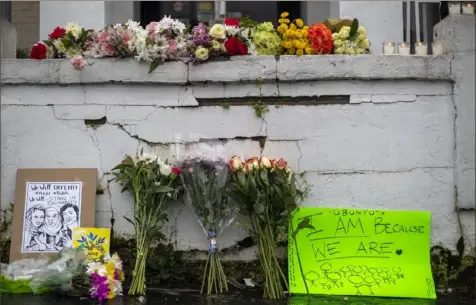  ?? Alyssa Pointer/Atlanta Journal-Constituti­on via AP ?? Flowers and signs sit at a makeshift memorial outside the Gold Spa in Atlanta on Wednesday. Eight people, six of them women of Asian descent, were killed Tuesday by a gunman at the Gold Spa and two other Atlanta-area massage businesses.