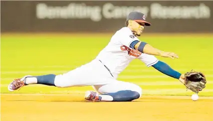  ??  ?? Francisco Lindor, torpedero de los Indios, fildea con elegancia un duro roletazo bateado por Salvador Pérez, receptor de los Reales de Kansas City. El boricua conectó un triple, remolcó una carrera y anotó dos.