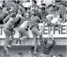  ??  ?? Horrific event: Liverpool fans pull people to safety in the ill-fated Leppings Lane end