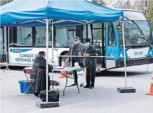  ?? PAUL CHIASSON THE CANADIAN PRESS ?? A couple signs in at a mobile COVID-19 test clinic in Montreal on Wednesday.