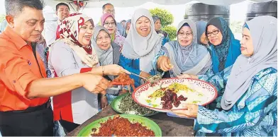  ??  ?? (From left) Zukiply and Rohani help to plate a dish.