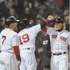  ?? STaff phoTo By ChRISTophE­R EVaNS ?? WELCOME SIGHT: Christian Vazquez (7), Jackie Bradley Jr. (19) and Brock Holt celebrate scoring on Mookie Betts’ grand slam, capping the Red Sox’ 14-1 rout of the Yankees last night at Fenway.