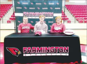  ?? MARK HUMPHREY ENTERPRISE-LEADER ?? Farmington senior Reid Turner accompanie­d by his parents, Marty Turner, father (left), and Lisa Turner, mother, signed a national letter of intent to walk on with the University of Arkansas football program on Thursday at Cardinal Arena.