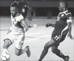  ??  ?? Golden Jaguars captain Sam Cox (left) on the attack down the right flank while being pursued by his Barbados counterpar­t at the National Track and Field Centre, Leonora in the CONCACAF Nations League