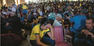  ?? YORK TIMES VICTOR MORIYAMA/THE NEW ?? Supporters of former President Jair Bolsonaro are detained Monday in Brasilia, Brazil.