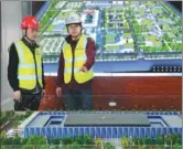  ?? WANG JING / CHINA DAILY ?? Workers of China State Decoration Group Co., check a scale model of the Citizen Service Center on Thursday.