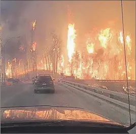  ?? SUBMITTED ?? A wall of flames motorists hoped to beat as they fled last year’s wildfire in Fort McMurray, Alta.