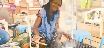  ?? — Reuters photos ?? Timdi grilling fish at her stall in Yaounde, Cameroon on Aug 23.