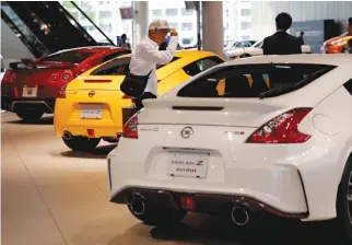  ?? REUTERS ?? A MAN WALKS in the Nissan showroom at the car maker’s headquarte­rs in Yokohama, Japan, May 11, 2017.