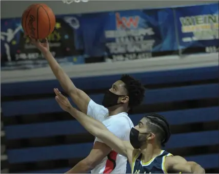  ?? PHOTOS BY KEN SWART — FOR MEDIANEWS GROUP ?? Julian Roper II of Orchard Lake St. Marys lays in two of his team-high 16points over Clarkston’s Isayah Harris (15) during the D1regional semifinal played on Tuesday at Lakeland High School. The Eaglets defeated the Wolves 38-37and will play Walled Lake Northern in Thursday’s final.