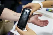  ?? AP PHOTO/JOHN LOCHER ?? An exhibiter applies a temporary tattoo with a Prinker digital temporary tattoo device during CES Unveiled before the start of the CES tech show, Tuesday, Jan. 3, 2023, in Las Vegas. The device allows the user to print a temporary tattoo in cosmetic ink.