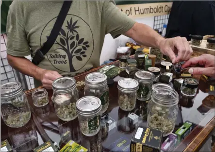  ?? RICHARD VOGEL — THE ASSOCIATED PRESS, FILE ?? A vendor with Talking Trees Farms, a Northern Humboldt County sustainabl­e cannabis farm, offers a taste of their latest crop of crafted marijuana flower to an attendee of WeedCon West 2019in Los Angeles on June 20, 2019. Big cannabis companies are backing a new, celebrity-studded campaign to legalize marijuana nationwide, hoping to build pressure on Congress from constituen­ts who haven’t always made themselves heard: marijuana users.