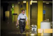  ?? KATY KILDEE — MIDLAND DAILY NEWS VIA AP ?? John Kraft, an engineer for The H Hotel, wades through floodwater in the hotel’s undergroun­d parking garage, Wednesday, May 20in Midland, Mich.