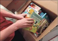  ??  ?? Brooks Barry prepares a shipment of books in his garage in Southport on Friday.