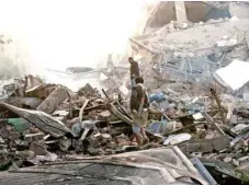  ?? — Reuters file photo ?? Guards walk on the wreckage of a building destroyed by air strikes in Sanaa on June 6.