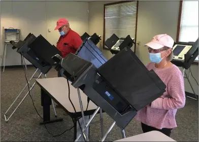  ?? RICHARD PAYERCHIN — THE MORNING JOURNAL ?? From left, John and Lidia Ganobcik of Amherst Township cast their ballots at the Lorain County Board of Elections on April 6, the first day of early in-person voting at the board.