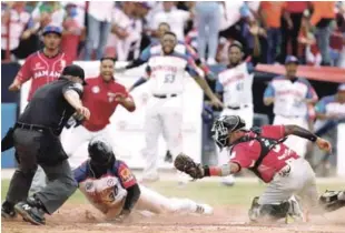  ??  ?? Emilio Gustave, de República Dominicana, llega a salvo al plato, mientras que el receptor Rodrigo Vigil, de Panamá, trataba de ponerlo out este viernes, durante un partido de la Serie del Caribe.