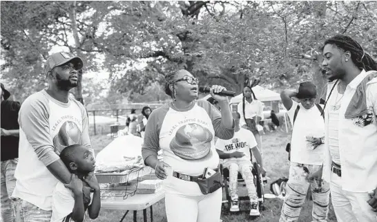  ?? ARMANDO L. SANCHEZ/CHICAGO TRIBUNE ?? Octavia Mitchell talks with attendees during a memorial gathering July 17 for her son, Izael Jackson, who was shot to death in 2010.