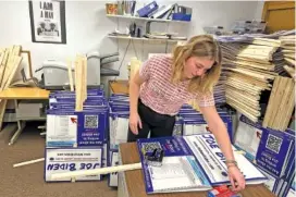  ?? AP PHOTO/WILL WEISSERT ?? Emily Vering, a 20-year-old volunteer and sophomore at St. Olaf College, assembles a yard sign Wednesday as part of a course she is taking on campaigns and politics in Hooksett, N.H.