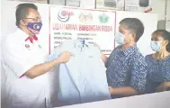  ??  ?? FOKUS: Mohd Salim mendengar penjelasan daripada suami Louna. mengenai baju-baju korporat yang dihasilkan oleh syarikat mereka. Turut kelihatan Louna.