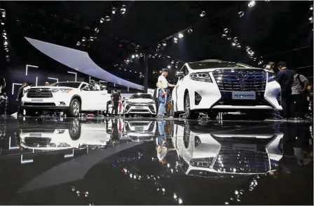  ??  ?? Smart partnershi­p: Visitors look at Toyota models at Guangzhou auto show. Toyota has signed an agreement with Suzuki Motor Corp for it to receive EVs from its smaller peer for the Indian market. — Reuters