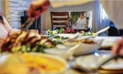  ?? John Minchillo / Associated Press ?? An image of Ana Martinez, the recently deceased mother of sisters Vivian Zayas and Alexa Rivera, rests at the head of the table.