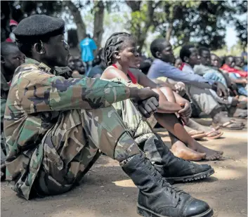  ?? STEFANIE GLINSKI/GETTY IMAGES ?? Newly released child soldiers attend sit as they attend their release ceremony in Yambio, South Sudan, on Wednesday. More than 300 child soldiers, including 87 girls, have been released in South Sudan’s war-torn region of Yambio under a programme to...