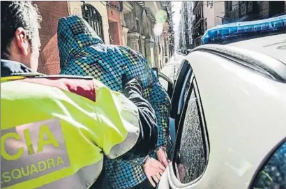  ?? XAVIER CERVERA ?? Los mossos trasladan a uno de los doce detenidos el martes en el transcurso de una importante operación
