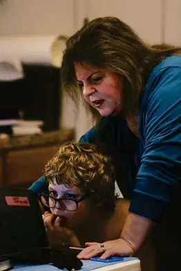  ?? Photos by Jerry Lara / Staff photograph­er ?? Sheila Ryan helps her son Benjamin, 9, a fourth grader in the Great Hearts Online virtual academy, before the start of class at their home Friday.