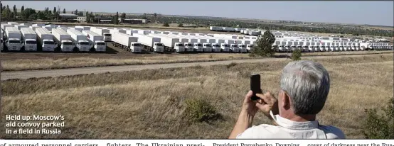  ??  ?? Held up: Moscow’s aid convoy parked in a field in Russia