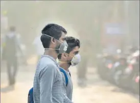  ?? BIPLOV BHUYAN/HT ?? People wear pollution masks as smog descended on the national capital, on Monday.