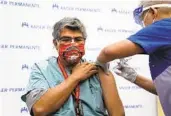  ?? JAE C. HONG AP ?? Respirator­y care practition­er Raul Aguilar receives a COVID-19 vaccine at a Kaiser facility in Los Angeles. Kaiser has suspended 2,200 unvaccinat­ed employees.