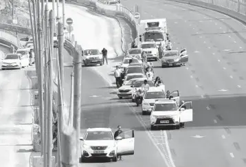  ?? SEBASTIAN SCHEINER/AP ?? Moment of silence for Holocaust victims: Israelis stand next to their cars Thursday in Tel Aviv as sirens mark a nationwide moment of silence in remembranc­e of the 6 million Jewish victims of the Holocaust. One of the most somber days in Israel, Holocaust memorial day marks the anniversar­y of the 1943 Warsaw Ghetto uprising.