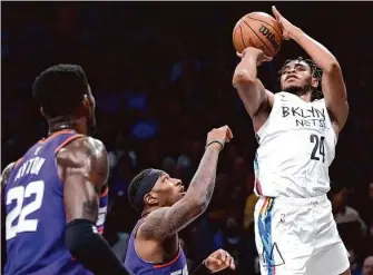  ?? Mary Altaffer/Associated Press ?? Nets guard Cam Thomas, who scored 43 points, shoots a three-point basket over Phoenix center Deandre Ayton (22) and forward Torrey Craig during the first half in Brooklyn.