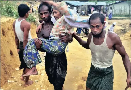  ??  ?? Rohimullah, 25, carries his mother-in-law Gulseher into a tent city in Balukhali, Bangladesh. Their family has settled there, among more than 430 000 Rohingya refugees fleeing persecutio­n in Myanmar. PICTURE: MAX BEARAK/THE WASHINGTON POST